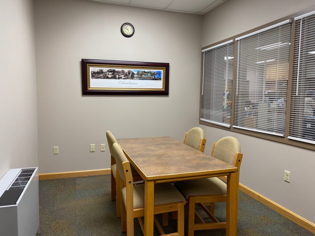 an image depicting the small conference room with a small table and four chairs around it